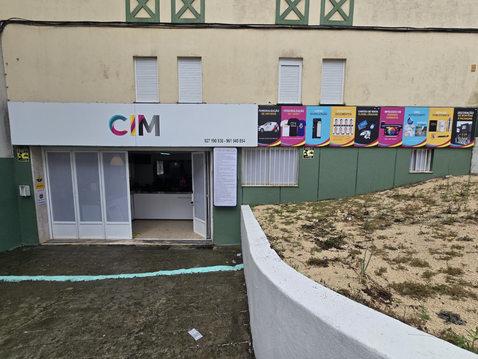 Fachada da loja CIM com logótipo e painéis coloridos que apresentam os serviços